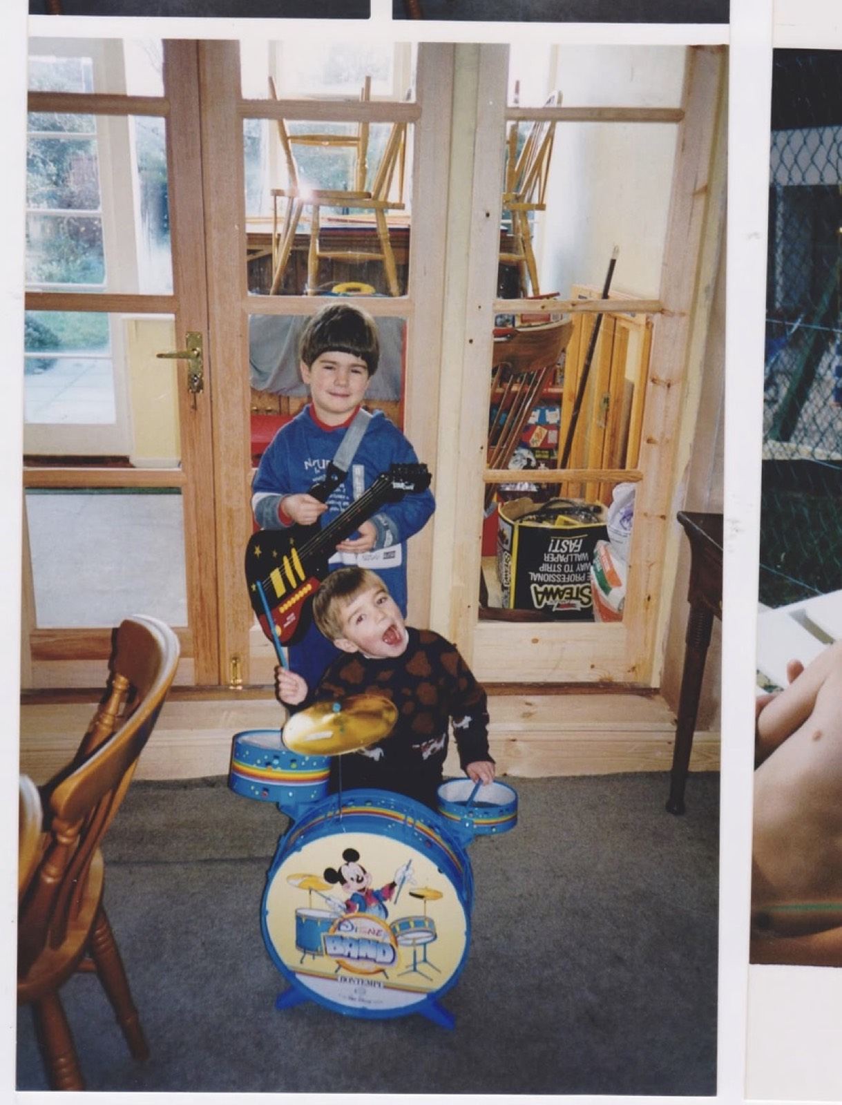 Two young brothers playing together at home, in an old family photograph