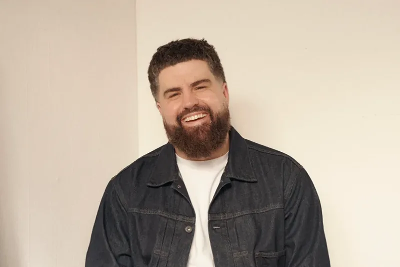 James Hazlett-Beard, laughing, in a denim jacket