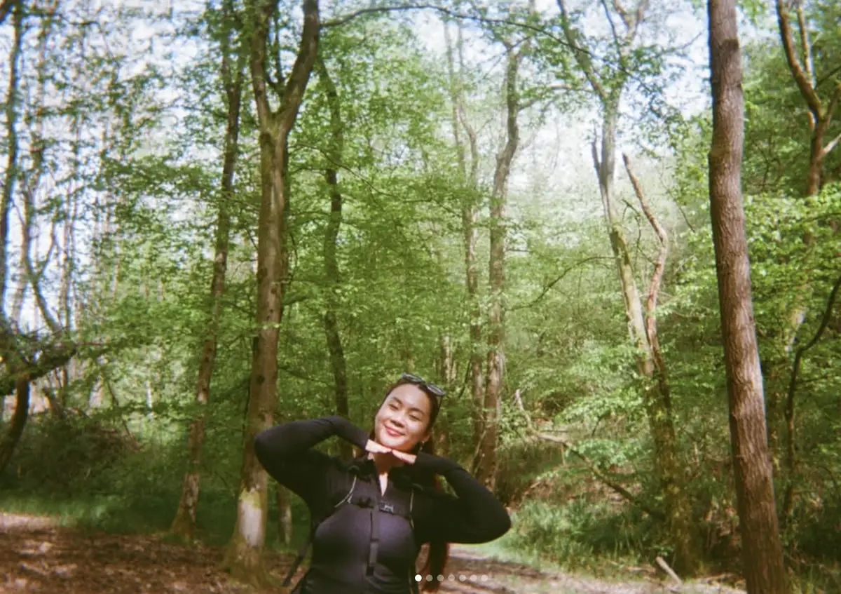 Mickey Jones smiling among tall green trees on a woodland walk