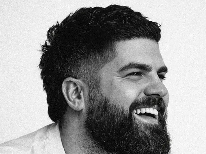 James Hazlett-Beard, laughing, in black and white