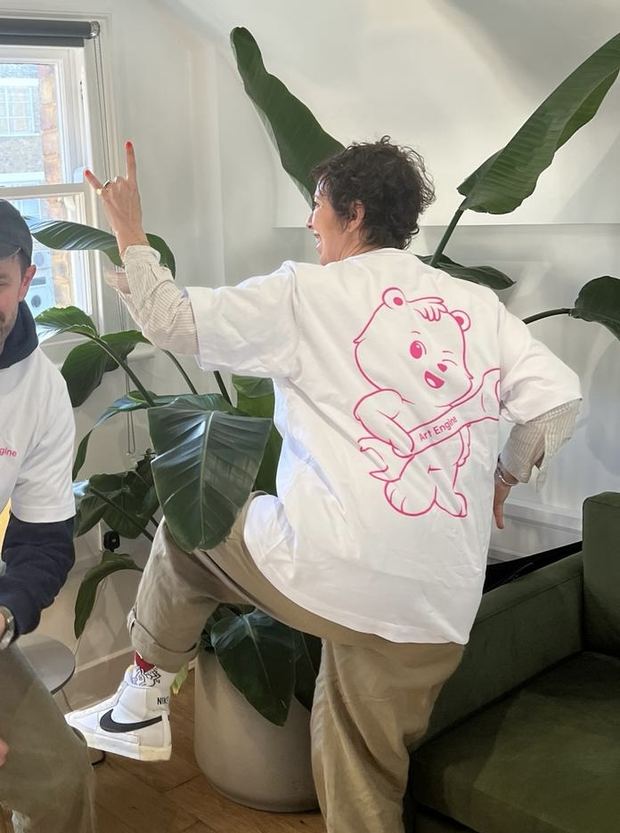 Someone dancing in the office, the winking bear across the back of their shirt