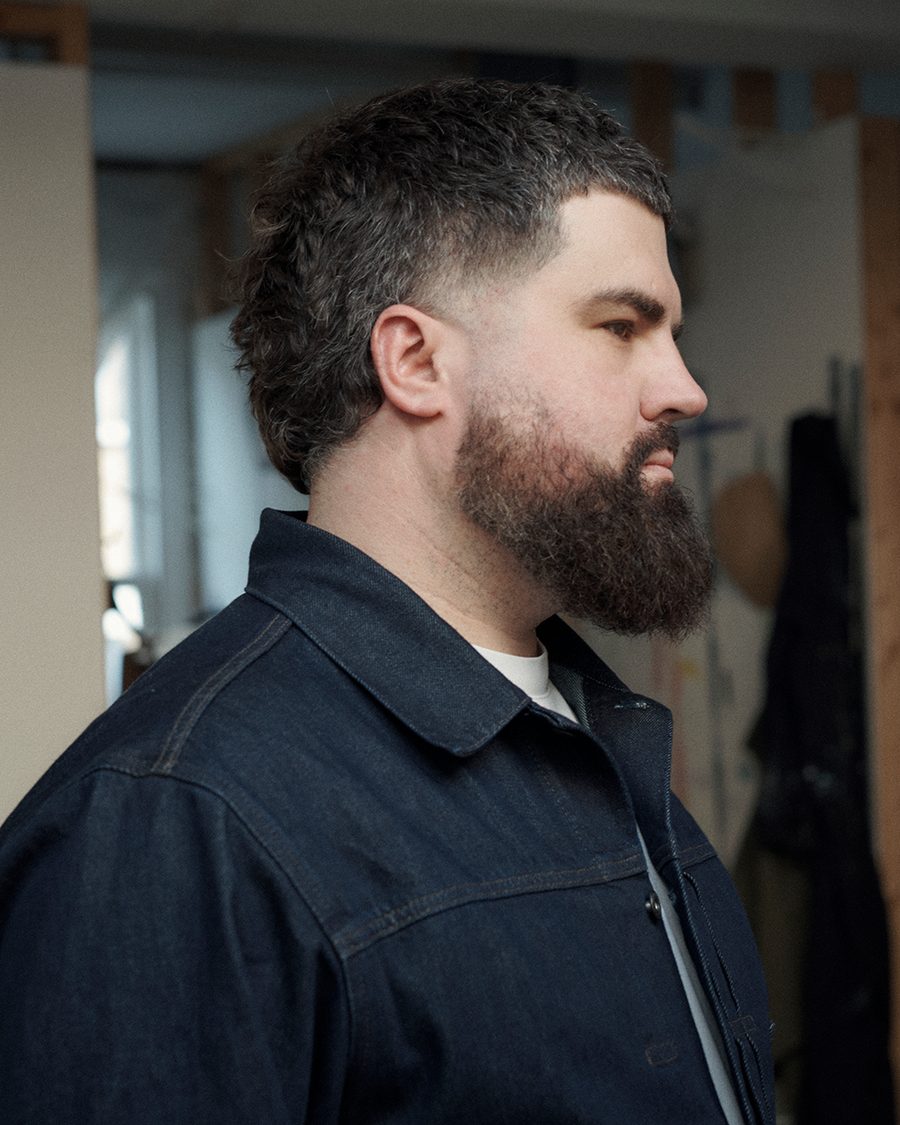 James in profile in a denim jacket, looking off to one side